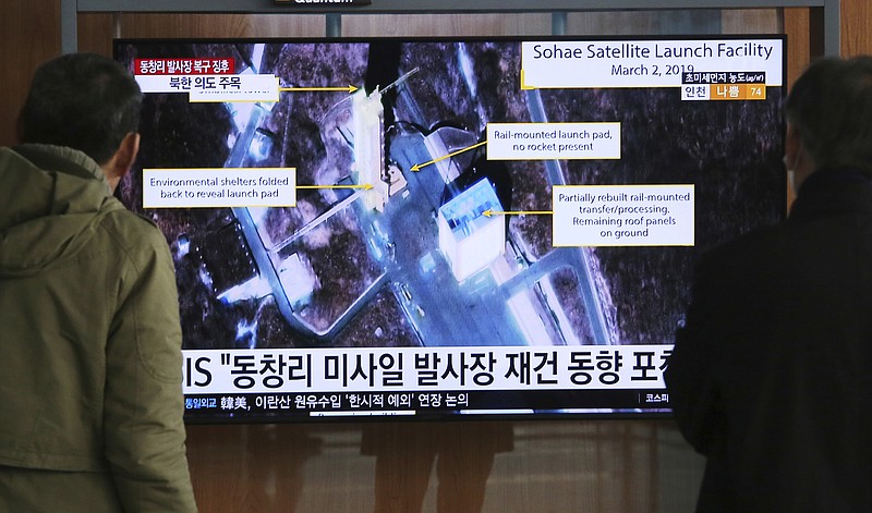 FILE - In this March 6, 2019, file photo, people watch a TV screen showing an image of the Sohae Satellite Launching Station in Tongchang-ri, North Korea, during a news program at the Seoul Railway Station in Seoul, South Korea. North Korea on Saturday, Dec. 14, says it successfully performed another "crucial test" as its long-range rocket launch site that would further strengthen its "reliable strategic nuclear deterrent."The signs read: " North's Tongchang-ri launch site." (AP Photo/Ahn Young-joon, File)