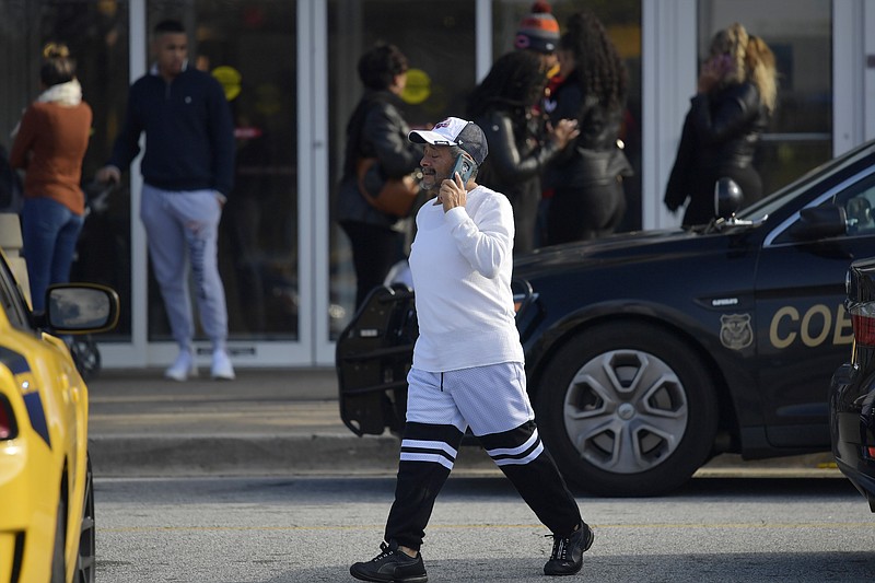 A man walks to his vehicle as authorities investigate an incident at Cumbnerland Mall, Saturday, Dec. 14, 2019, in Smyrna, Ga. (AP Photo/Mike Stewart)