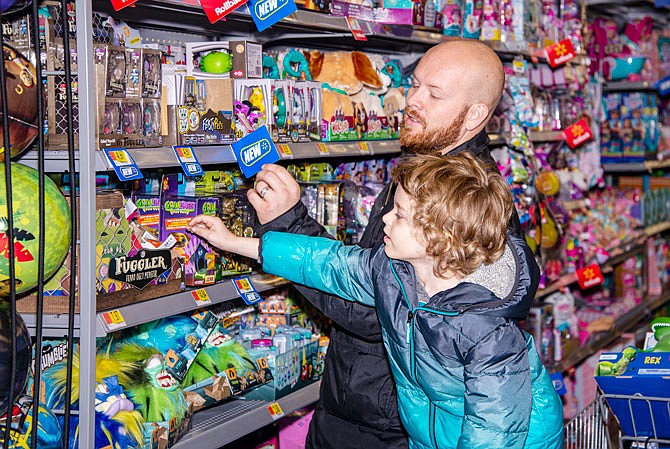 Algoa Corrections Officer Dustin Flamm helps Riley Rawlings pick out his Christmas presents Saturday at the annual Operation TOYS at Walmart.