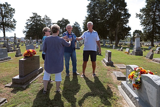 Ed Morrison, far right, toasts his deceased brother with his wife, Mindy, far left, and longtime friends, Mary Kay Webb (back turned), and Bob Moll in the in Holy Childhood of Jesus Cemetery in Mascoutah, Illinois on Wednesday, Oct. 2, 2019. Mike Morrison, 18, and his prom date, Debbie Means, 15, were murdered after their prom night on May 3, 1969. The two are buried next to each other in the cemetery. Ed and Mindy have written a book in commemoration of the 50th anniversary of the deaths.  (Cristina M. Fletes/St. Louis Post-Dispatch/TNS) 