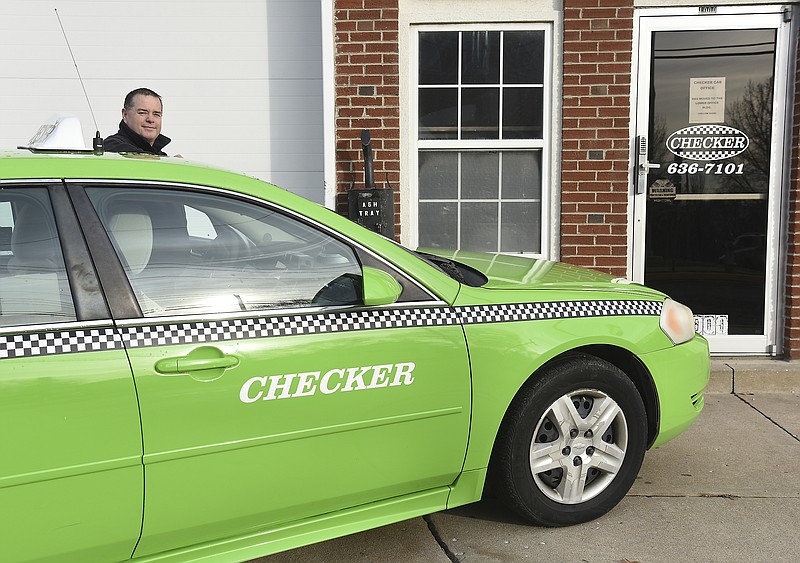 Checker Cab Company Jefferson City manager Allen Elliott poses next to the familiar green cab. Check officially closed at 9:00 a.m. Thursday, Jan. 1, 2020. Owner Tom Landwehr plans to semi-retire so will be closing the city's only formal taxi service.