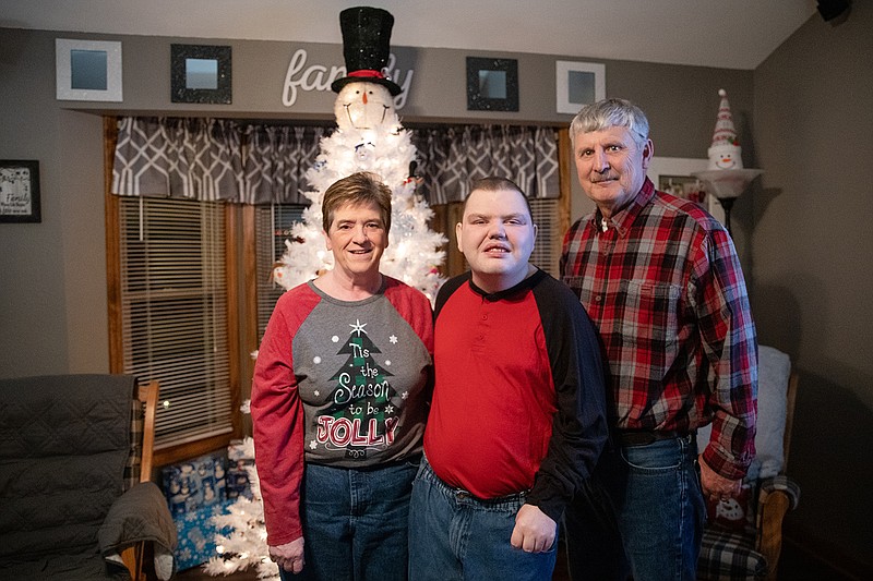 Vicki Bock, left, and Paul Bock pose with their son Dylan, center, in their home. Dylan is a full-time employee at Capitol Projects, a United Way partner agency.