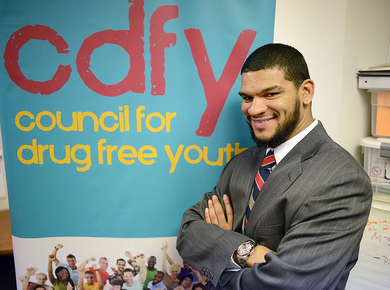 Samuel Butler stands in front of a poster at the Council For Drug Free Youth office. Since being released from prison six months ago, Butler has been working to become a youth drug counselor for at risk youth.