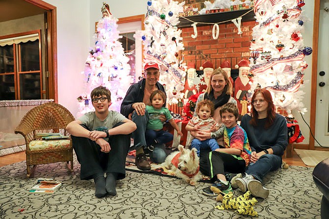 The Dyer family sits around the Christmas decorations in their home. From left is Christopher, Curtis holding grandchild Loukas, family dog Suki, Lisa holding grandchild Aeros, Kaden and Abby. The Dyer family has adopted six children through Missouri foster care and has 14 children overall.