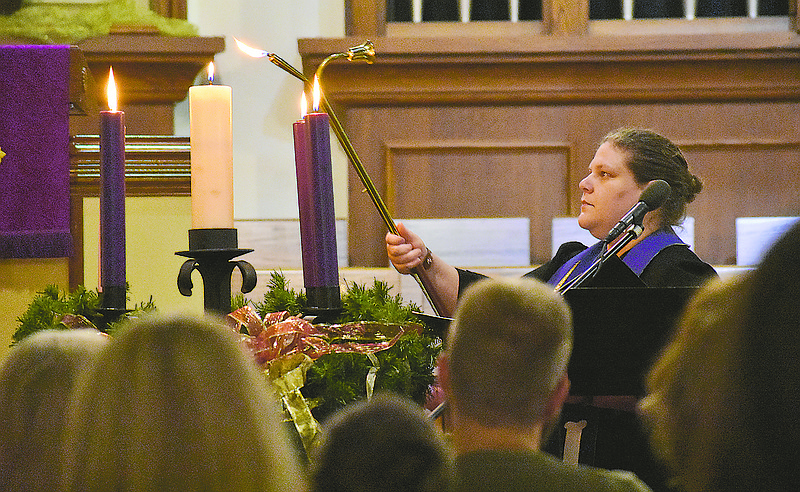 The Rev. Sarah Kingsbery lights an Advent Wreath candle during Sunday's Blue Christmas service.