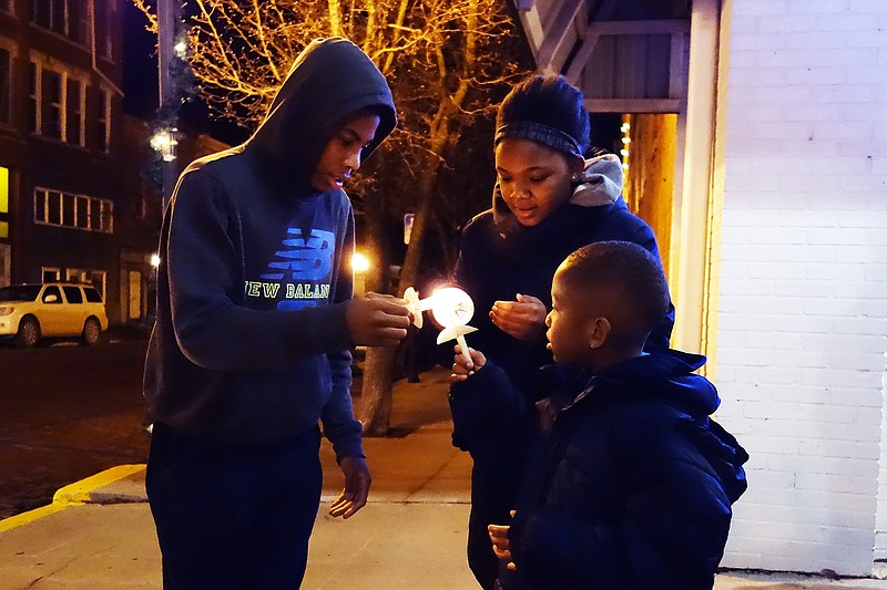 Brynn Bynum (left) and Taji Braxton help Jishawn Braxton keep his candle lit. Following music at the Art House, participants at the "Re-Remembering Celia" ceremony joined a candlelight procession to the Callaway County Courthouse.