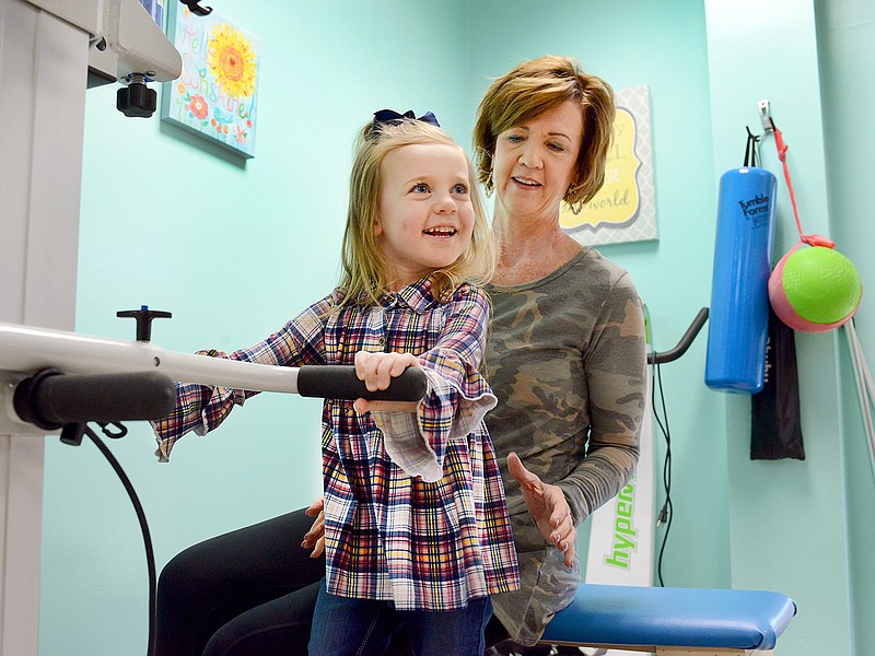 Olivia McCullough, 4, walks on a treadmill Dec. 10 in front of physical therapist Mary Owens at the Special Learning Center. McCullough was diagnosed with SCN1A, a rare genetic disease, at 10 months old.