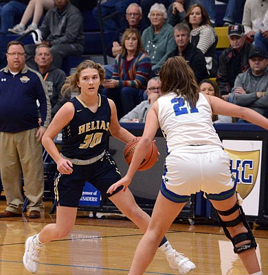 Ella Meyer of Helias attempts to dribble past McKenna Lester of Blue Springs South during Friday's game at Rackers Fieldhouse.
