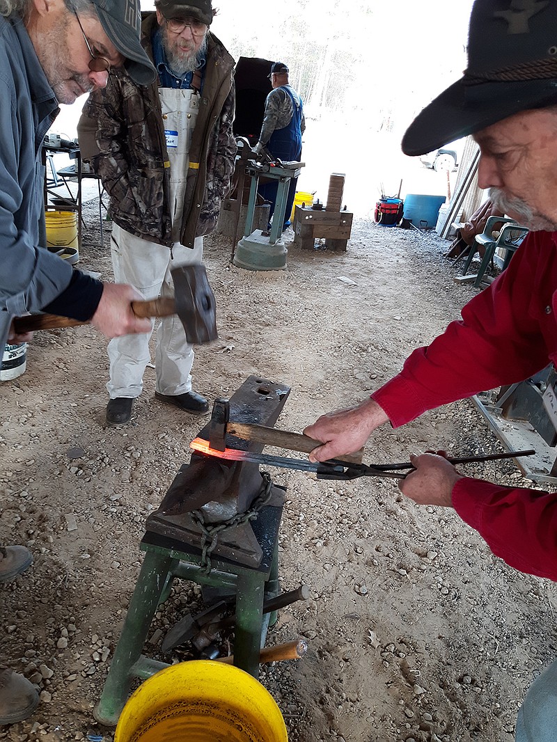 Four States Iron Muncher members Mark Lanier and Mickey Sisco work metal together during a December club meeting. Blacksmiths from across the Four States Area come to practice their craft at the meetings.