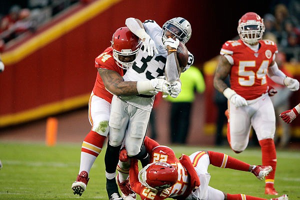 Chiefs defensive tackle Mike Pennel (top) helps bring down Raiders running back DeAndré Washington during a game earlier this month at Arrowhead Stadium.