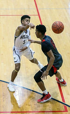 Isaac Johnson of Helias makes a pass over Sterling DeSha of the Jays during Sunday's third-place game of the Joe Machens Great 8 Classic at Fleming Fieldhouse.