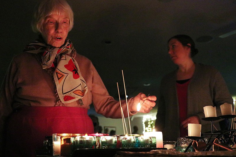 A community member lights a candle in honor of the new year Monday during the Unitarian Universalist Fellowship's Evening of Community and Hope.