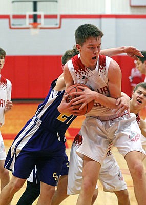 Trevin White of Calvary Lutheran secures a rebound during Thursday's game against Chamois at Calvary.