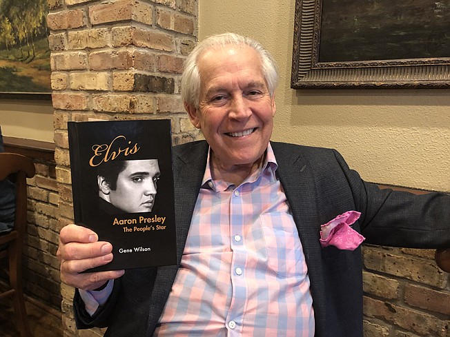 Former New Boston, Texas, resident Gene Wilson displays a copy of his most recent book, "Elvis Aaron Presley: The People's Star." Wilson spent about five months writing the book before publishing it last August. He will be in New Boston on Saturday to promote the book.