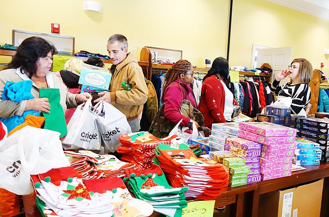 FILE: Adopt-a-Family recipients pick through Santa's Room, a side room full of extra goodies in 2019. Those pictured include Donita Ballard, left, Rick Ballard, Casey Griffin and Kelsey Hill.