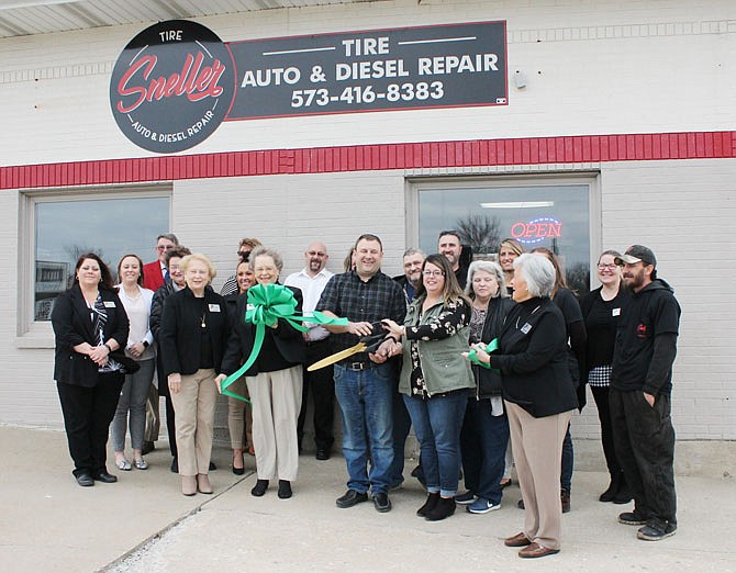 Randy and Requitta Sneller, owners of Sneller Tire Auto & Diesel Repair, cut the ribbon Thursday on their new Fulton auto repair shop.