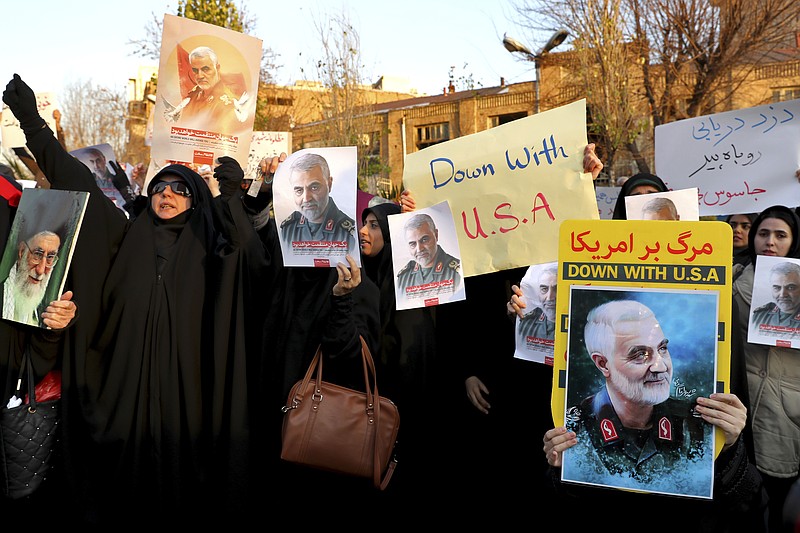 Protesters chant slogans and hold up posters of Gen. Qassem Soleimani during a demonstration in front of the British Embassy in Tehran, Iran, Sunday, Jan. 12, 2020. A candlelight ceremony late Saturday in Tehran turned into a protest, with hundreds of people chanting against the country's leaders — including Supreme Leader Ayatollah Ali Khamenei — and police dispersing them with tear gas. Police briefly detained the British ambassador to Iran, Rob Macaire, who said he went to the Saturday vigil without knowing it would turn into a protest. (AP Photo/Ebrahim Noroozi)
