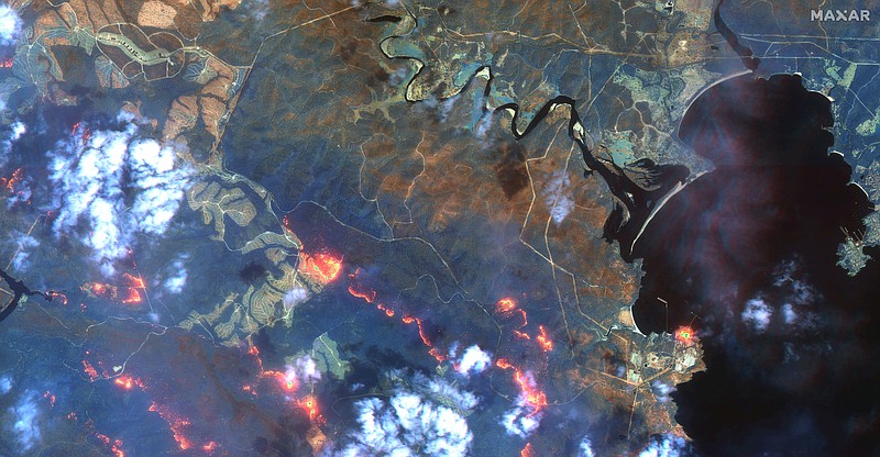 This satellite photo provided by Maxar Technologies shows wildfires spreading in the area south of Eden and Twofold Bay, shown in black, in New South Wales state of Australia, Sunday, Jan. 12, 2020. (Satellite image ©2020 Maxar Technologies via AP)