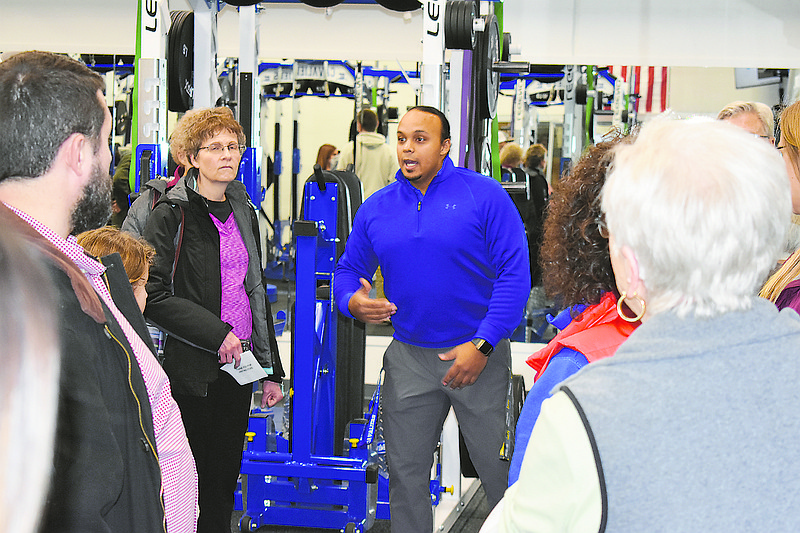 Alonzo Findley, middle, talks to people about Capital City High School's weight room during Sunday's public tour of the new high school. Findley is the strength conditioning coach at the school.