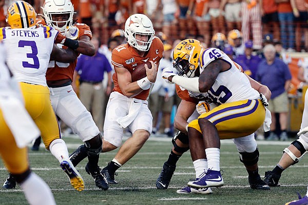 LSU linebacker Michael Divinity closes in on Texas quarterback Sam Ehlinger during a game this season in Austin, Texas.