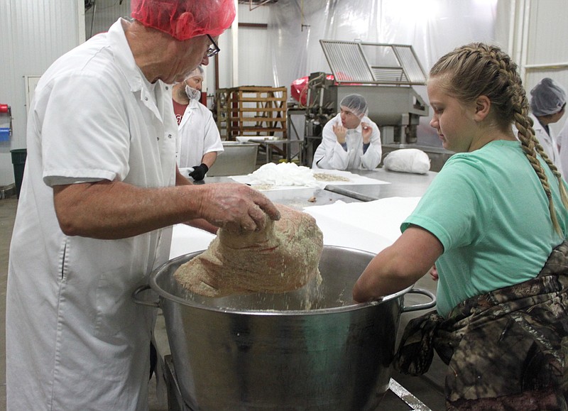Katie Pryor, 10, selects the perfect ham to start the curing process Jan. 11, 2020, at Burgers' Smokehouse. Pryor and a good number of other 4-H club members learned how to cure a ham.
