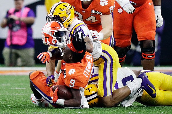 LSU safety Grant Delpit knocks the helmet off Clemson running back Travis Etienne during Monday night's College Football Playoff national championship game in New Orleans.