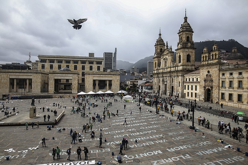 FILE - This June 10, 2019 file photo shows activists who have received death threats displaying the names of killed leftist activists as part of an art installation by Colombia artist Doris Salcedo at Plaza Bolivar in downtown Bogota, Colombia.  The United Nations High Commissioner for Human Rights expressed alarm Tuesday, Jan. 14, 2020 at the “staggering number” of social activists killed in Colombia despite a peace accord aimed at improving conditions in poor, rural areas. (AP Photo/Ivan Valencia, File)