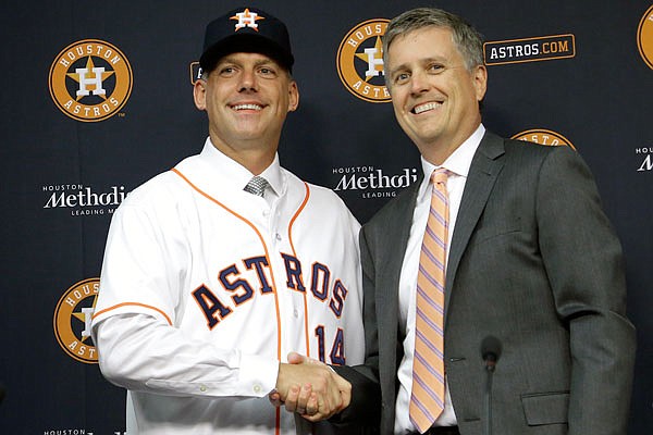 In this Sept. 29, 2014, file photo, Astros general manager Jeff Luhnow and A.J. Hinch pose after Hinch is introduced as the new manager of the team in Houston.