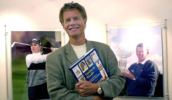 In this Aug. 21, 2003, file photo, IMG vice chairman Alastair Johnston poses outside his office with one of his books in Cleveland. Johnston has the largest collection of golf books in the world, and he's gifting it to the R&A.