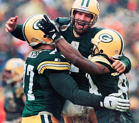 In this Jan. 4, 1997, file photo, Packers teammates (from left) John Michels, Brett Favre and Andre Rison celebrate after Green Bay's Antonio Freeman recovered a fumble for a touchdown during a playoff game against the 49ers in Green Bay, Wis.