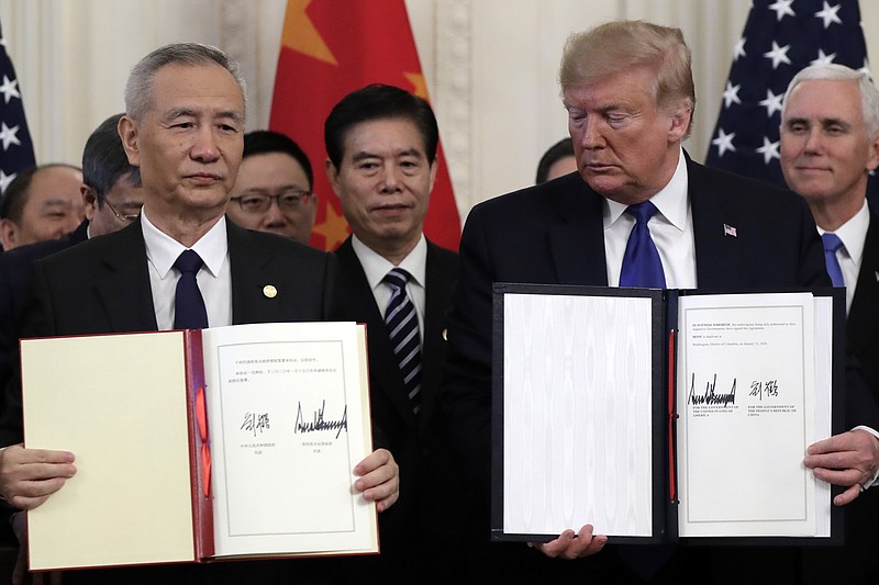 President Donald Trump holds the signed a trade agreement with Chinese Vice Premier Liu He, in the East Room of the White House, Wednesday, Jan. 15, 2020, in Washington. (AP Photo/Evan Vucci)