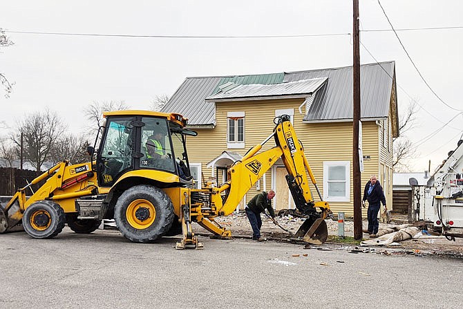 City of Fulton employees clean up litter at 212/214 E. Sixth St. After months of litigation, the city has purchased the property and will be selling it to GloveCon.