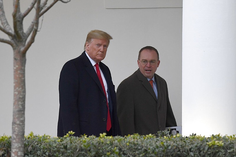 In this Jan. 13, 2020. file photo, President Donald Trump, left, and acting White House chief of staff Mick Mulvaney, right, walk along the colonnade of the White House in Washington. The federal government's watchdog agency says a White House office violated federal law in withholding security assistance to Ukraine aid. The Government Accountability Office said Thursday the White House Office of Management and Budget violated the law in holding up the assistance. (AP Photo/Susan Walsh, File)