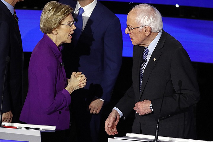 Democratic presidential candidate Sen. Elizabeth Warren, D-Mass., left and Sen. Bernie Sanders, I-Vt., talk Tuesday, Jan. 14, 2020, after a Democratic presidential primary debate hosted by CNN and the Des Moines Register in Des Moines, Iowa. Candidate businessman Tom Steyer looks on (AP Photo/Patrick Semansky)