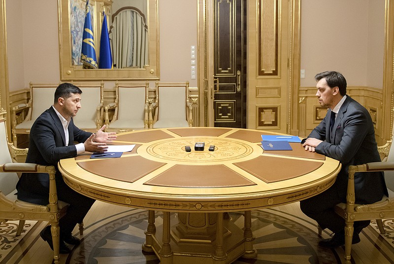 In this photo provided by the Ukrainian Presidential Press Office, Ukrainian President Volodymyr Zelenskiy, left, talks with Ukraine's Prime Minister Oleksiy Honcharuk in Kyiv, Ukraine, Friday, Jan.17, 2020. Honcharuk earlier submitted his resignation to parliament following a leaked audio recording which suggested he had criticised the president. (Ukrainian Presidential Press Office via AP)