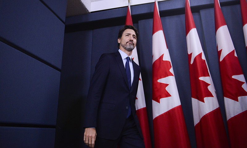 Canada Prime Minister Justin Trudeau arrives at a press conference at the National Press Theatre in Ottawa, Friday, Jan. 17, 2020. Trudeau said Friday his government will give $25,000 Canadian ($19,122 U.S.) to families of each of the 57 citizens and 29 permanent residents of Canada who perished in the downing of a Ukrainian jetliner in Iran last week. (Sean Kilpatrick/The Canadian Press via AP)