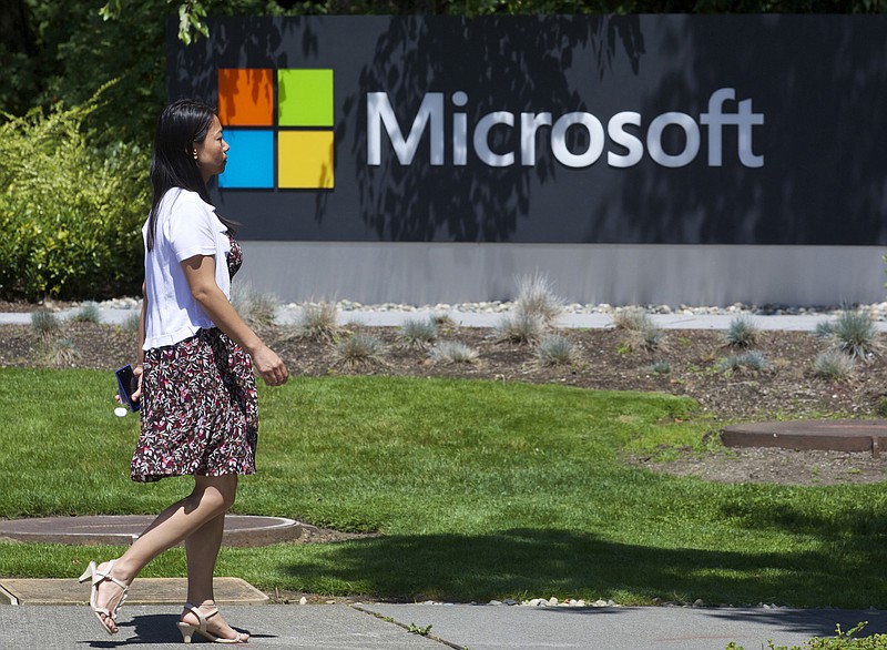 A pedestrian walks a sign on Microsoft Headquarters campus July 17, 2014 in Redmond, Wash. (Stephen Brashear/Getty Images/TNS)