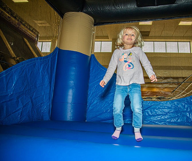 Olivia Schneider, 2, jumps in the bounce house Saturday at the Leapfrog Inflatable Rentals Capital Mall MLK Weekend 2020 event. 