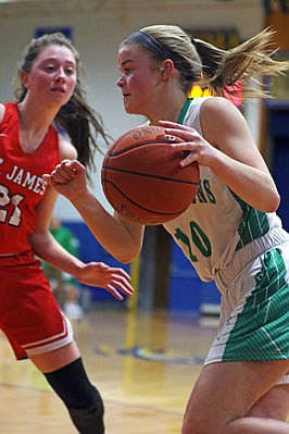 Alyssa Hargus of Blair Oaks dribbles past Hannah Marcee of St. James during Saturday night's Comet Classic championship game in Westphalia.