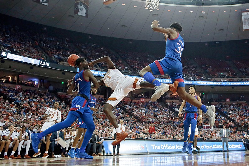 Texas guard Andrew Jones (1) is fouled by Kansas guard Marcus Garrett (0) as he tries to score during the second half of an NCAA college basketball game, Saturday, Jan. 18, 2020, in Austin, Texas. (AP Photo/Eric Gay)