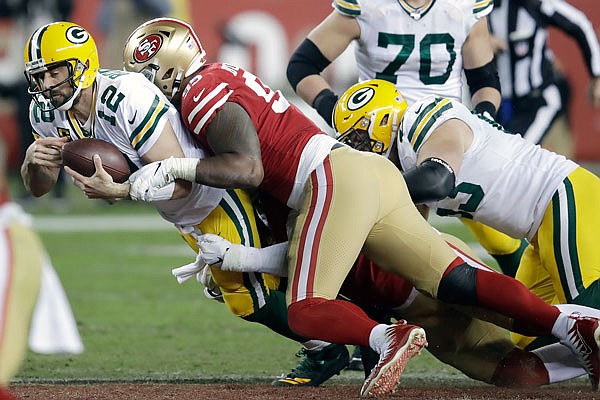 Packers quarterback Aaron Rodgers is sacked by 49ers defensive tackle DeForest Buckner (center) and defensive end Arik Armstead during a Nov. 24 game in Santa Clara, Calif.