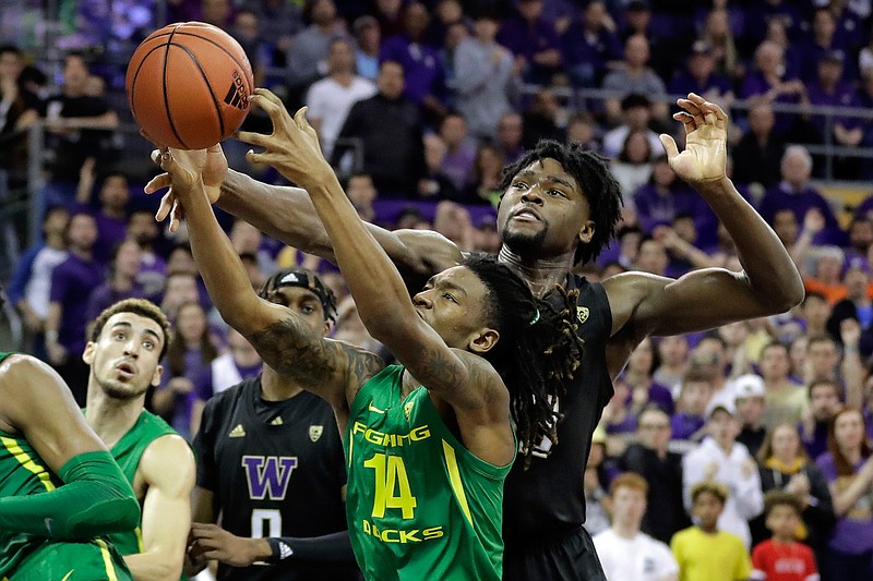 Oregon forward C.J. Walker (14) battles for the ball with Washington forward Isaiah Stewart, right, during the second half of an NCAA college basketball game, Saturday, Jan. 18, 2020, in Seattle. Oregon won 64-61 in overtime. (AP Photo/Ted S. Warren)