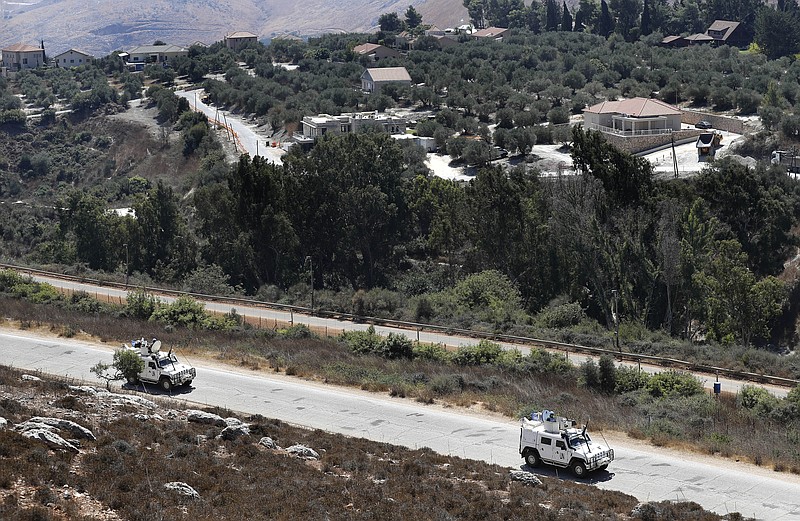 FILE - Sept. 2, 2019, file photo, Spanish UN peacekeepers patrol along the Lebanese-Israeli border, with the Israeli village of Metulla, background, in the village of Kfar Kila, Lebanon. Israel's military said it began construction of an underground defense system Sunday along its northern frontier with Lebanon to protect against cross-border tunnels. (AP Photo/Hussein Malla, File)