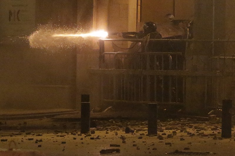 Riot police fire rubber bullets against the anti-government protesters, during ongoing protests against the political elites who have ruled the country for decades, in Beirut, Lebanon, Sunday, Jan. 19, 2020. Lebanese security forces used tear gas, water cannons and rubber bullets in clashes with hundreds of anti-government protesters outside the country's Parliament on Sunday, as violence continued to escalate in a week of rioting in the capital. (AP Photo/Hassan Ammar)