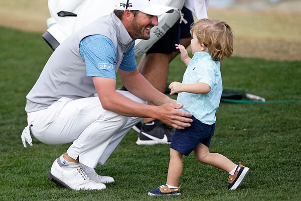 Andrew Landry (left) greets his son, Brooks, on the 18th hole Sunday after winning The American Express on the Stadium Course at PGA West in La Quinta, Calif.