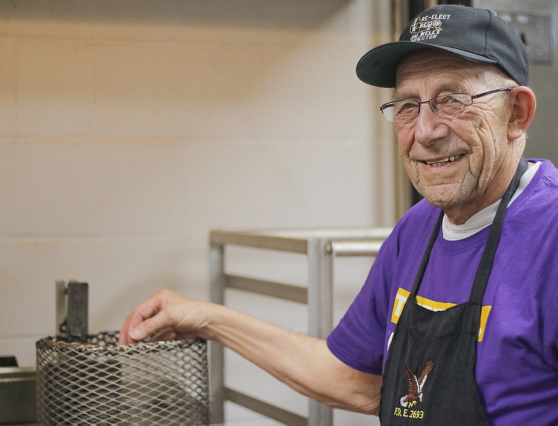 Bill Reinkemeyer poses for a portrait Friday in front of a trip of fryers in the kitchen of the Eagles Club. Reinkemeyer is in charge of frying all the chicken for the club's meal service, and can handle all three of the fryers at once.