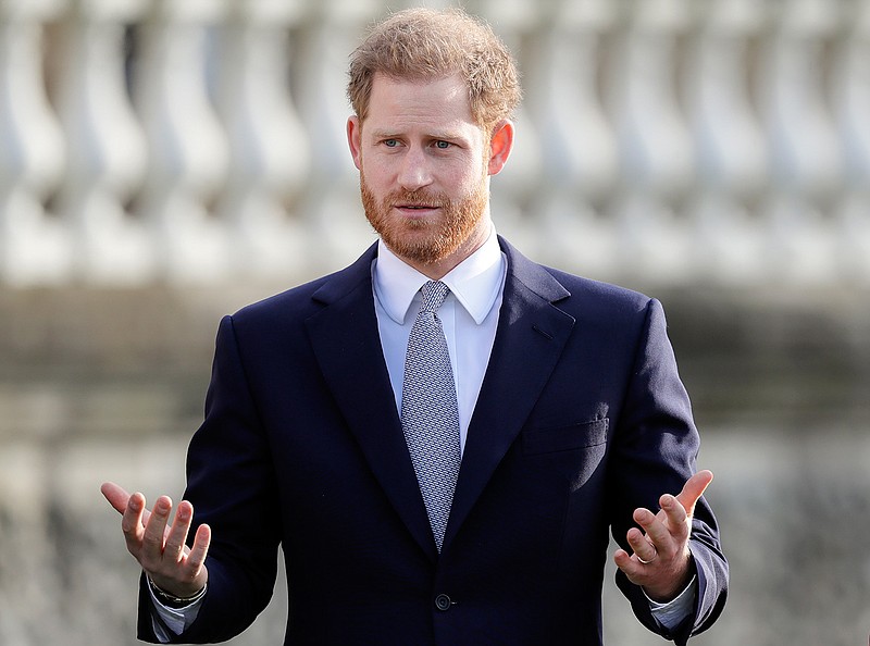 Britain's Prince Harry gestures Thursday in the gardens of Buckingham Palace in London. 