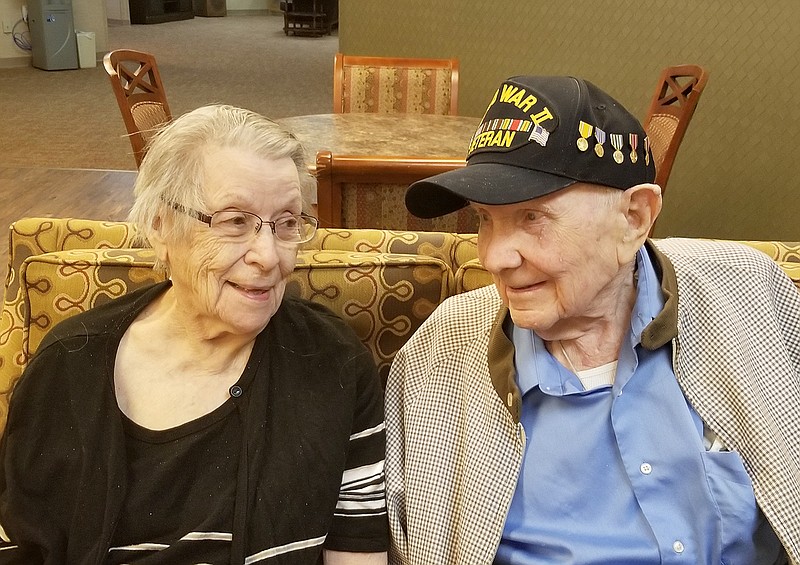Cliff Mathis, a 102-year-old military veteran, shared stories of his military service while his wife of 71 years, Alice, listens. Mathis fibbed about his age to enlist in the Missouri National Guard when only 17 years old and later became an officer, serving overseas during World War II.