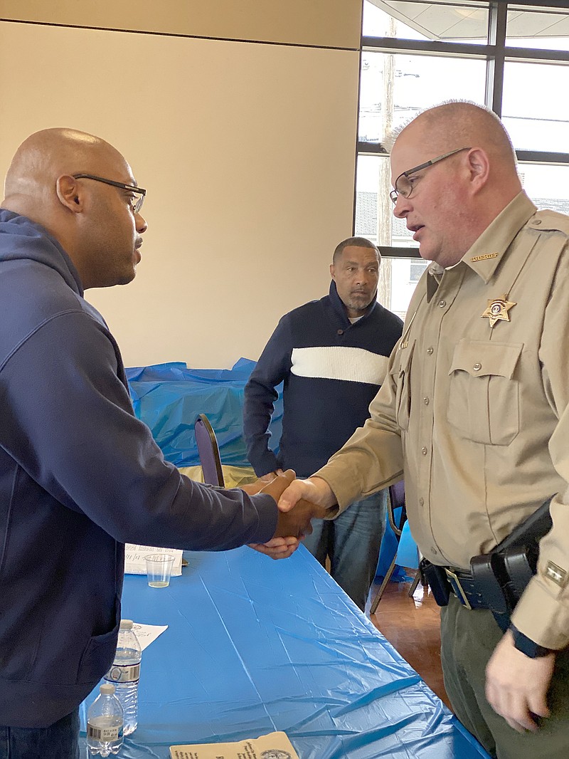 Ricky Kidd shakes hands Monday with Cole County Sheriff John Wheeler at a Martin Luther King, Jr. Day prayer breakfast at Quinn Chapel A.M.E. Church in Jefferson City. Kidd was freed last year from a life sentence in prison after a court ruled he had been wrongly convicted.