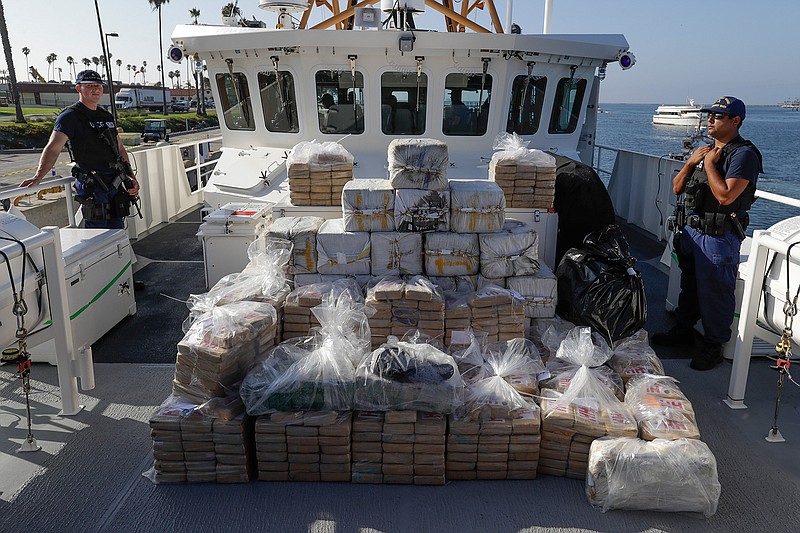  In this Aug. 29, 2019, file photo, members of the Coast Guard stand near seized cocaine in Los Angeles. The nation's drug addiction crisis has been morphing in a deadly new direction: more Americans struggling with meth and cocaine. Now the government will allow states to use federal money earmarked of the opioid crisis to help people addicted to those drugs as well. The change to a $1.5 billion opioid grants program was buried in a massive spending bill that Congress passed late in 2019. (AP Photo/Chris Carlson, file)